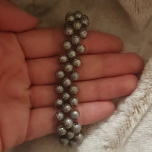 Glittrigt silverfärgat pärlarmband - Snyggt armband med glittriga silverfärgade pärlor i två rader. Pärlorna har en skimrande yta som ger extra bling och armbandet stängs med en klassisk karbinhake. Perfekt för dig som gillar att sticka ut med accessoarer!