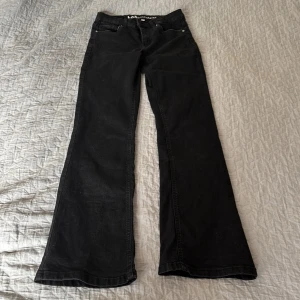 Svarta bootcut jeans från LAB Industries - Svarta jeans från LAB Industries i bootcut-modell med klassisk femficksdesign och dragkedja. 