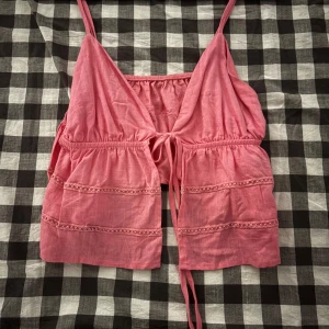 Rosa  linnetopp med spetsdetaljer - Söt rosa linnetopp med omlott-design och knyt framtill. 