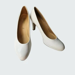 Vita platåpumps i lack från Gabor - Nya och helt oanvända platåpumps från Gabor med rund tå och elegant hög klack. Skorna har en stilren design i vitt syntetlack som ger en fräsch och modern look. En Soft & Smartsula i skinn för en riktigt skön komfort. Klädd klack och präglad yttersula för att inte vara hal. Snygga pumps både till kostymbyxor eller klänning. Finns dock ett litet märke i fram på vänster skor, se bild nr 5. Ligger runt 1000 kr i nypris. Rökfritt, men katt finns i hemmet.
