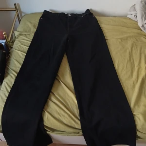 Svarta manchesterbyxor från Lindex - Säljer ett par svarta manchesterbyxor från Lindex i storlek 36. Byxorna har raka, breda ben och klassiska bakfickor. Materialet är mjuk manchester som ger en cool retrovibe. Perfekt för dig som gillar en avslappnad och trendig stil.