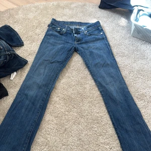 Blå bootcut jeans från rock republic  - Snygga blå jeans från rock republic med klassisk bootcut passform. Jeansen har gul kontrastsöm, fem fickor och cool broderad detalj på bakfickorna. Tillverkade i slitstarkt denim med dragkedja och knapp framtill. Perfekta för dig som gillar en tidlös och avslappnad stil. Liten i storlek 