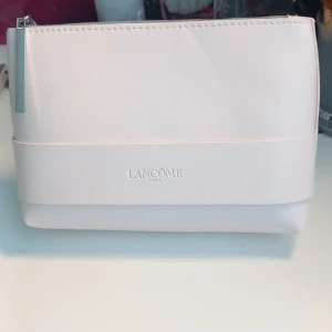 Lancôme hudvårdskit med necessär - Snyggt hudvårdskit från Lancôme med ljusrosa necessär i konstläder, en 15ml ljuslila Rénergie H.P.N. 300-Peptide Cream, en 15ml  lila Rénergie Multi-Lift Nuit nattkräm, en 7ml svart Advanced Génifique serum och en 3ml vit Advanced Génifique Yeux ögonkräm. Perfekt för dig som vill boosta din hudvårdsrutin med lyxiga produkter och prova mindre versioner av produkterna innan du köper en större version.