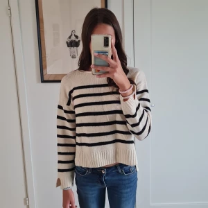 Randig, svartvit tröja - Randig svartvit tröja med splittade ärmar. Denna tröja har tyvärr 2 röda färgklickar av någon sorts målarfärg.