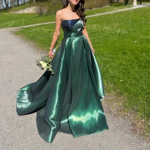 Smaragdgrön festklänning - Axelbandslös smaragdgrön festklänning. Storlek 36-38, klänningen kan justeras då den har en korsett. Ordinarie pris 10 000, exklusiv egendesignad klänning i Turkiet Klänningen kan även passa större Skriv privat för mer information endast användt 1 gång. Pris går att diskuteras! 