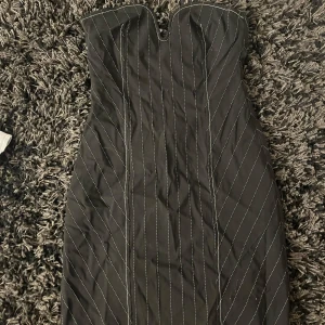 Svart axelbandslös klänning från Zara - Snygg svart axelbandslös klänning från Zara med vita ränder. Klänningen har en figurnära passform och en dragkedja i sidan. Så snygg till festliga tillfällen som t.ex. nyårsafton 🥰🥰