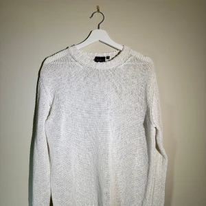 Vit stickad tröja från Oscar Jacobson - Snygg vit stickad tröja från Oscar Jacobson i storlek L. Tröjan har en klassisk rund halsringning och är långärmad. Perfekt för dig som gillar en clean och enkel stil med lite oversized känsla. Materialet är mjukt och skönt, passar till både jeans och chinos.