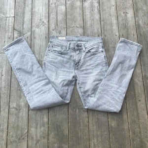 Levi's 511 grå jeans W28 L32 - Snygga grå Levi's 511 jeans med klassisk femficksdesign och läderpatch bak. Jeansen har en smal siluett och är tillverkade i mjukt jeanstyg som sitter skönt. Perfekt för dig som gillar en modern och stilren look. Om ni har några frågor så bara hör av er!