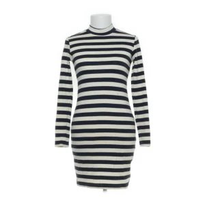 LMHD halv polo klänning i randigt marinblått å vitt strl XS - Snygg randig klänning från LMFD i marinblått och vit. Klänningen har en tight passform och är långärmad, perfekt för en stilren look. Tillverkad i mjuk bomull med lite stretch för extra komfort.LMHD halv polo klänning i randigt marinblått å vitt strl XS