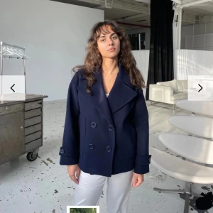 Mörkblå kappa - Snygg mörkblå kappa från Design By Si. Jackan har långa ärmar och en klassisk design som passar till många tillfällen.💙nypris ligger på 757kr