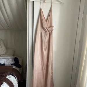 Långklänning  - Elegant champagnefärgad långklänning, snörning runt halsen med öppen rygg och slits. Använd endast en gång, passar perfekt som balklänning eller till bröllop✨😍
