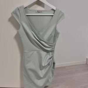 Blå/grön omlottklänning från Nelly - Superfin klänning från nelly som tyvärr inte passar mig😢 super bra skick, inga fläckar💕