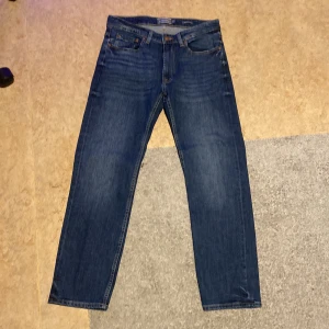 Blå jeans från Dressmann - Snygga blå jeans från Dressmann med regular fit. Klassisk design med fem fickor och knappgylf. Andvänt få gånger