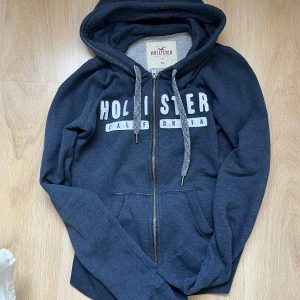 Hollister hoodie - Säljer denna mörkblåa zip-up hoodien från Hollister. Köpt här på Plick och endast använd två gånger av mig. Säljer då den inte kommer till användning. Den är gjord i ett mycket mjukt tyg och har hål för tummarna. Storlek XS 💕