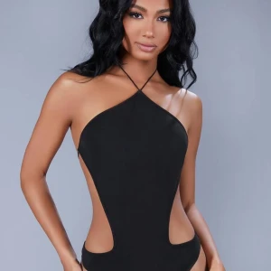 Svart body med öppen rygg - Elegant svart body med halterneck-design och öppen rygg. Perfekt för en utekväll eller fest. Använd endast en gång. Skriv om du vill se bilder jag själv tagit! 