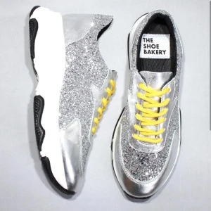 Glittriga sneakers från The Shoe Bakery - Snygga sneakers i silver med glittrig yta och gula snören från The Shoe Bakery. Köpta för 2200, använda väldigt få gånger (2-3 gånger)