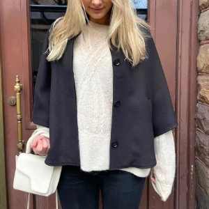 Svart trekvartsärmad poncho - Snygg svart kappa med trekvartsärm och knappar framtill. Perfekt för höst och vår🎀