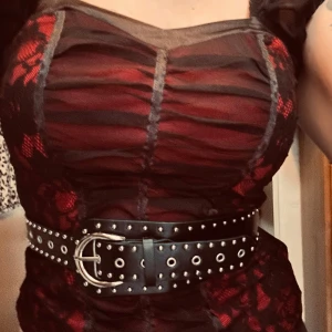 Svart vintagebälte! - Svart midjebälte i vintagestil med dekorativa nitar och stort spänne. Mått: L: 100 cm (35-100 cm från innersta till yttersta hålet). B: 4-8 cm. Oanvänt.