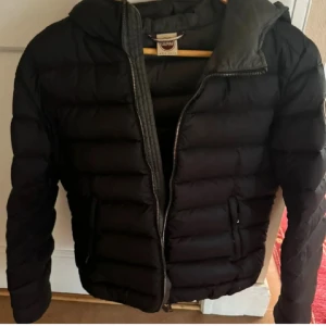 Colmar jacka - Snygg svart dunjacka från Colmar med huva och dragkedja framtill. Jackan är i mycket bra skick då den endast är använd två gånger, så jackan har inga defekter. Storleken på jackan är IT 44 men passar mig perfekt som är 164 och brukar ha S. Så skulle säga att den är i S ungefär.💕