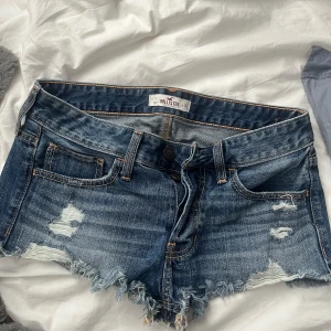 Blå lågmidja jeansshorts från Hollister - Säljer ett par snygga blå jeansshorts från Hollister. Storlek w26 eller xs/s!