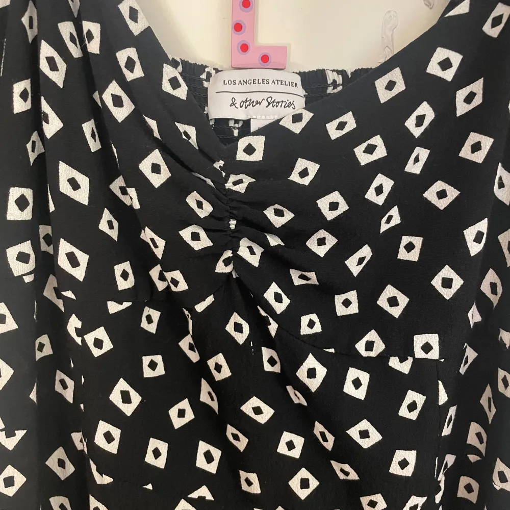 Snygg långklänning från & Other Stories med ett unikt svart och vitt mönster. Klänningen har korta puffärmar och en smickrande passform. Perfekt för en stilfull look.. Mekot.