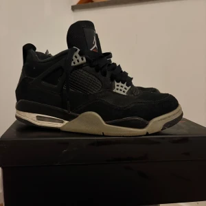 JORDAN 4 RETRO "BLACK CANVAS" - Nike Air Jordan 4 Retro SE i svart och grått med klassisk Jumpman-logga på hälen. Skorna har meshpaneler, snörning och detaljer i plast. Snygg kontrast mellan svart mocka och grå sula. Perfekta för dig som gillar streetwear och ikoniska sneakers. Köpta från Merch sweden 