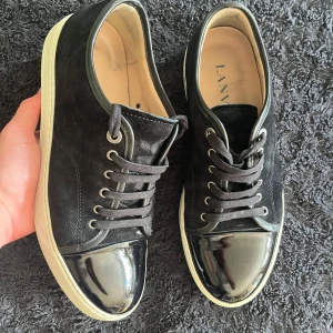 Lanvin skor - Ett par lanvin skor i skick enligt bilderna. UK8 ~ 42/43. Svart med glansig toe cap och vit sula. Box i okej skick, dustbag och extra snören medföljer vid köp