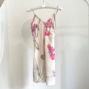 Blommig slipklänning från Leonard Lingerie - Säljer en ljus slipklänning från Leonard Lingerie med tunna axelband och vackert blommönster i rosa och lila toner. Passar storlek XS-S.