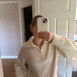 Beige stickad tröja med zip från & Other Stories - Säljer en fin och stilren beige stickad tröja från & Other Stories. Tröjan har hög krage med en zip dragkedja. 