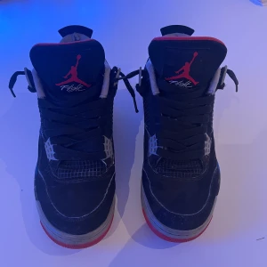 Nike Air Jordan 4 Retro Black/Red - Selling unisex authentic air jordan 4 Bred Reimagined shoes. Open to offers🤩 📏 Size: 40 EU Includes creaseguards and the original box, but it unfortunately has writings on it.😅  🔎 Condition: They have been worn regularly and show signs of wear- especially inside the heel area. And the outside has some small scratches (please see photos)  - Still comfortable and fully wearable.  🎨 Color: Black and red❤️🖤  💬 Message me if you want more photos or videos for authetication😇