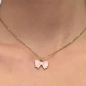 Rosett halsband rosa guld imitation  - Sött halsband med en berlock av en  en rosa rosett 🎀 Berlocken är ca 1,8 x 1 cm.  Kedjan är i guldimitation och justerbar 40-45 cm.   