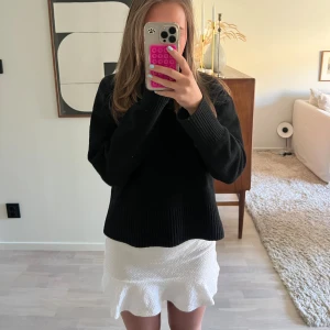 Vit kjol med rosett där bak  - En vit kjol med en knyt rosett på baksidan. Den är i strl 152.