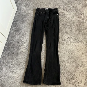 Svarta flare jeans - Svarta jeans från lager 157 i modellen Snake Flare. Byxorna har klassisk femficksdesign, hög midja och utsvängda ben. Snyggt svart tyg i jeansmaterial som passar perfekt till sneakers eller boots.