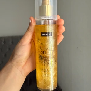 Sence Sunset Spirit Shimmering Mist - Shimmering body mist från Sence i Sunset Spirit-varianten. Ger en guldig glow med massor av skimmer och har en fräsch doft. Kommer i en genomskinlig plastflaska med sprayfunktion och guldigt innehåll.