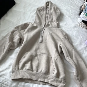 Beige hoodie från H&M Divided - Säljer en beige hoodie från H&M Divided i storlek S. Tröjan har huva med snörning, magficka och ribbade muddar. Perfekt för en chill och avslappnad stil. Materialet är mjukt och skönt, troligtvis bomullsmix.