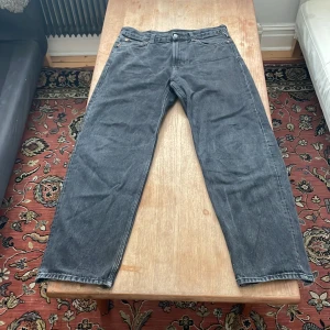 Svarta galaxy jeans från weekday - Säljer ett par svarta jeans med raka ben som har lite slitna benslut. Jeansen har klassisk femficksdesign och är tillverkade i denim. Perfekta för dig som gillar en lite ruffare streetstil.