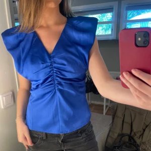 Blå satintopp med puffärmar - Blå blus från Coster copenhagen, nypris 999kr