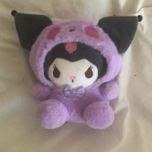 Jätte bra och ny  - Bilderna visar ett gosedjur i lila och svart med stora öron och en rosett, men ingen bok syns på bilderna. Vänligen ladda upp bilder på en bok för att få en beskrivning.