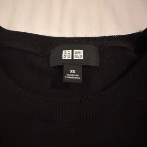 Svart merinoull tröja från Uniqlo - Säljer en stilren svart tröja från Uniqlo i storlek XS. Tröjan har en klassisk design med långa ärmar och rund hals. Perfekt för en minimalistisk look.