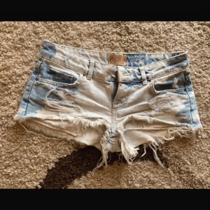 Blå och vita jeansshorts med fransar - Snygga blå och vita jeansshorts från Miss Me med slitna detaljer och fransar. Perfekta för en avslappnad stil. De har en låg midja och klassisk femficksdesign.