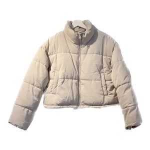 Puffer jacket - En beige puffer jacka 