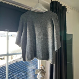 Grå stickad tröja från 157 - Säljer en mysig grå stickad tröja från 157. Perfekt för kyliga dagar med sin mjuka och bekväma passform. Tröjan har långa ärmar och en rund halsringning. Ett måste i garderoben för en stilren look.