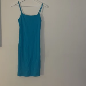 Blå klänning - Super fin, färgglad klänning från bikbok. Turkos/blå färg. Stretchigt material, har en åtsittande passform, slutar vid knäna. Helt oanvänd, prislappen är kvar.                                             Nypris: 259kr.                                                                    Mitt pris: 100kr❣️