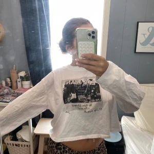 Vit croppad långärmad tröja med tryck - Säljer en vit croppad långärmad tröja med ett coolt tryck på framsidan. Tröjan har en lös passform och är gjord i bomull. Merket ar Pepe Jeans. 