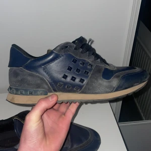 Valentino rockrunners - Snygga Valentino sneakers i en kombination av blått och grått. Skorna har en unik design med nitar på sidan och en bekväm sula. Perfekta för dig som vill ha en stilren look med en twist.