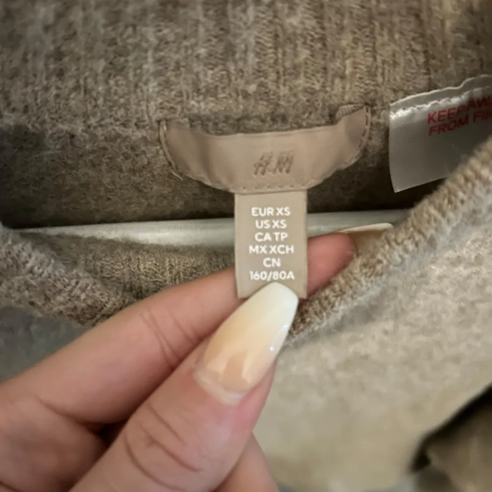 Säljer en mysig beige stickad tröja från H&M. Tröjan har en croppad passform och långa ärmar. Den är enkel och stilren med ribbad halsringning. Aldrig använt men prislapp är inte kvar.. Neuletakit & Villapaidat.