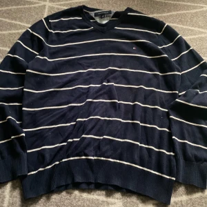 Tommy Hilfiger tröja - Halvtunn vit/mörkblå tröja av Märket Tommy Hilfiger,  Storlek L men är töjbar Nytt skick Postar inom 24h. Kontakta vid frågor!