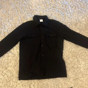 Overshirt  - Snygg svart långärmad overshirt från selected homme med två fickor på framsidan. Overshirten är använd endast en gång och finns inga defekter på den alls. Bara att höra av sig vid frågor.