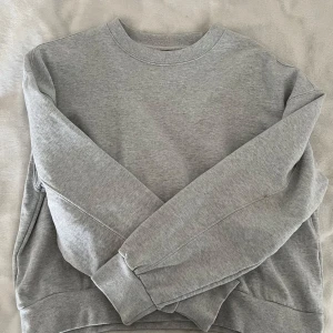 Grå sweatshirt från Dr. Denim - Säljer en stilren grå sweatshirt från Dr. Denim. Tröjan har en klassisk rund halsringning och långa ärmar. Perfekt för en avslappnad look. 🩶