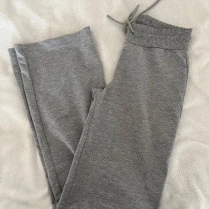 Grå mjukisbyxor från 157 - Säljer ett par grå mjukisbyxor från 157 i storlek XS. Byxorna har en bekväm resårmidja med snörning och är perfekta för en avslappnad stil. De är tillverkade i mjukt material som ger en skön känsla hela dagen.
